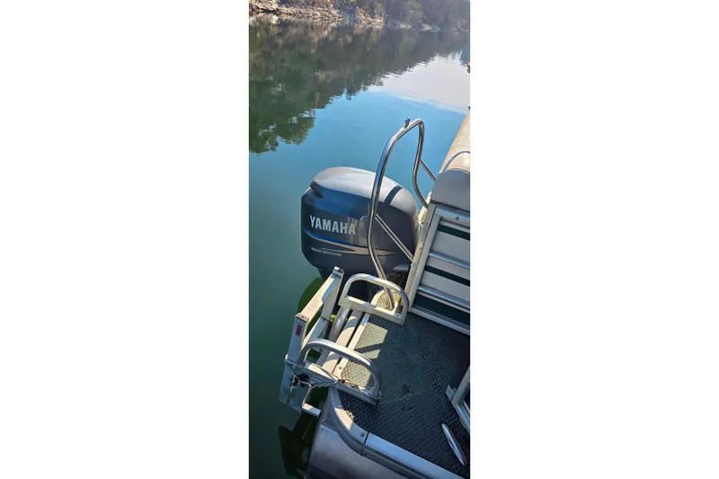 Slide: The Image of 2004 Sanpan 2500 RE pontoon boat with Yamaha outboard motor on calm water. - 24