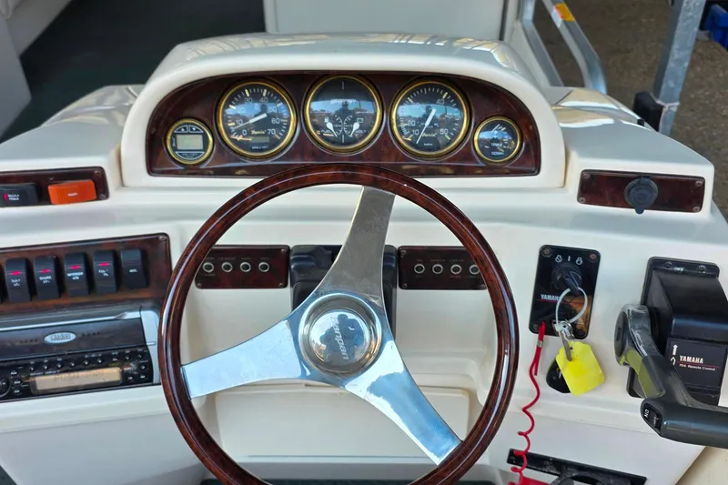 Slide: The Image of 2004 Sanpan 2500 RE boat dashboard with Yamaha controls and steering wheel. - 32
