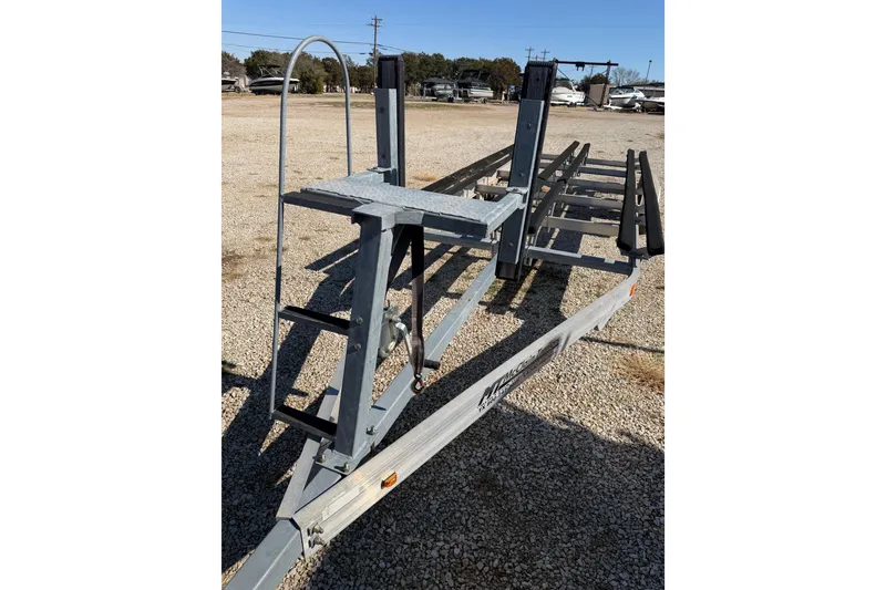 Slide: The Image of Boat trailer parked on gravel lot, near Sanpan 2500 RE, 2004 model. - 36