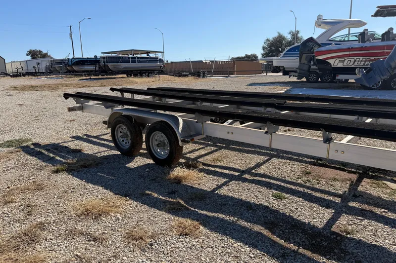 Slide: The Image of 2004 Sanpan 2500 RE boat trailer on gravel lot, featuring sturdy metal frame. - 37