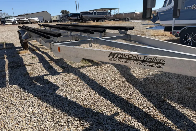 Slide: The Image of Trailer for 2004 Sanpan 2500 RE boat on gravel lot with other boats. - 38