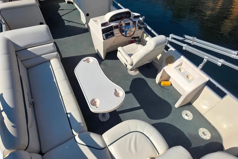 Slide: The Image of 2004 Sanpan 2500 RE pontoon boat interior with seating, table, and steering console. - 4