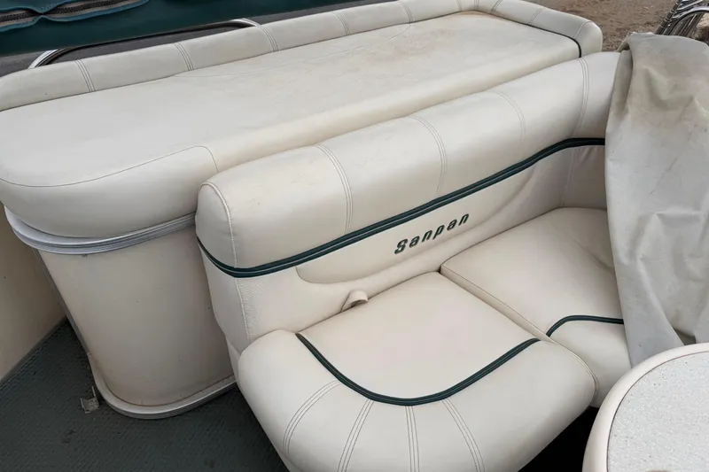 Slide: The Image of 2004 Sanpan 2500 RE boat seating with white upholstery and green accents. - 50