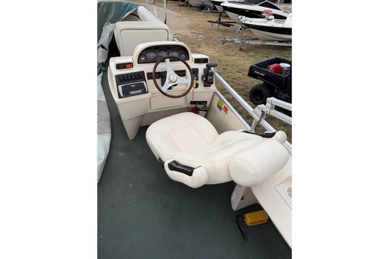 Slide: The Image of 2004 Sanpan 2500 RE boat helm with steering wheel and control panel. - 51