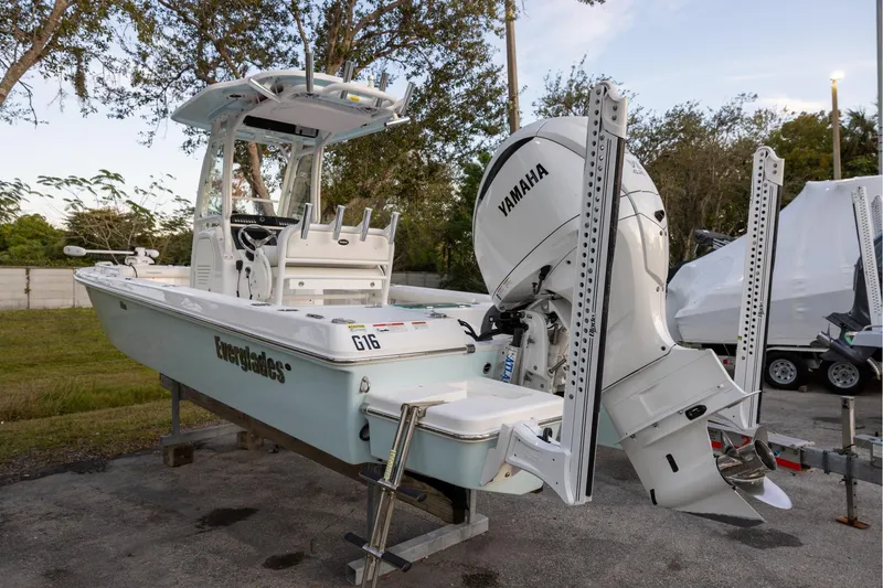 Slide: The Image of 2023 Everglades 243 Center Console boat with Yamaha engine, parked outdoors. - 2