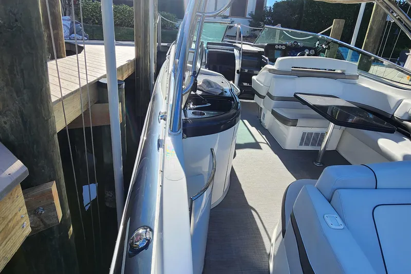 Slide: The Image of 2017 Formula 370 Super Sport boat interior with seating and table, docked at a marina. - 16