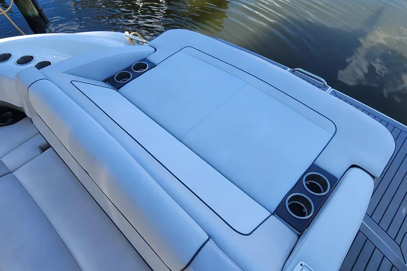 Slide: The Image of 2017 Formula 370 Super Sport boat with cushioned seating and cup holders by the water. - 19