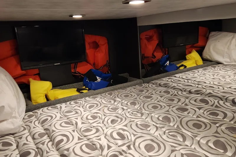 Slide: The Image of 2017 Formula 370 Super Sport cabin with TV, life jackets, and patterned bedding. - 62