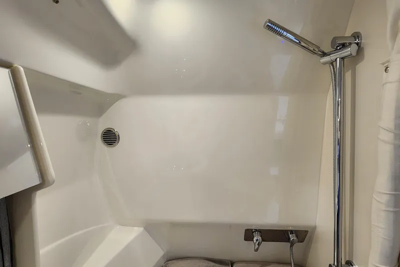 Slide: The Image of 2017 Formula 370 Super Sport boat shower interior with chrome fixtures and white walls. - 66