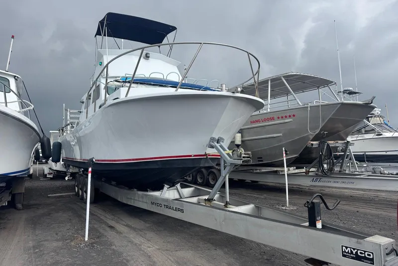 Slide: The Image of 1988 Custom 36 Hawaiian Lightning Radon boat on trailer, overcast sky background. - 11