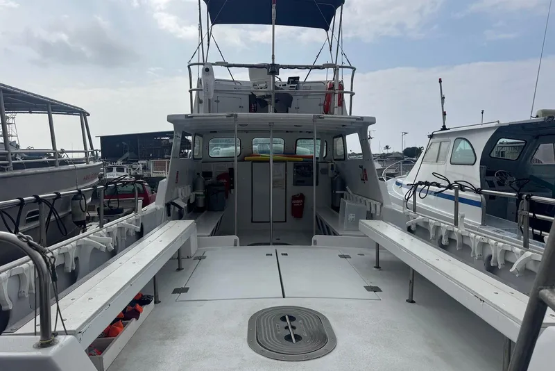 Slide: The Image of 1988 Custom 36 Hawaiian Lightning Radon boat docked, featuring spacious deck and seating. - 13