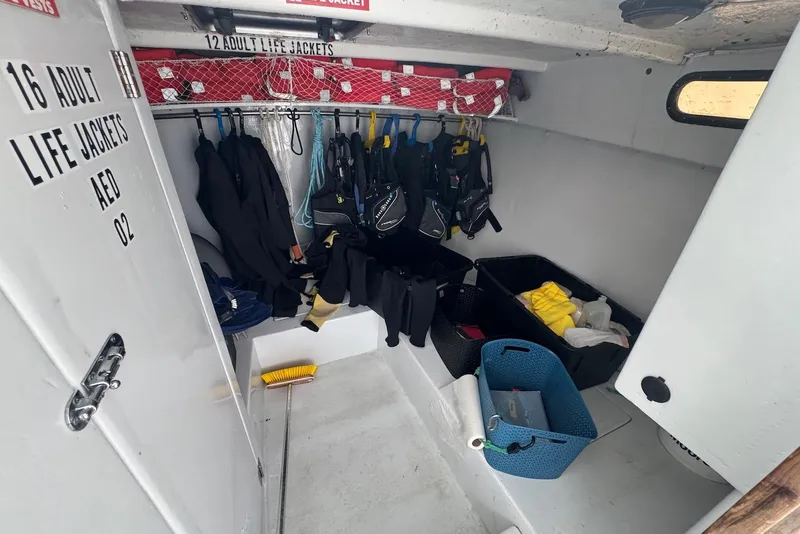 Slide: The Image of Interior of 1988 Custom 36 Hawaiian Lightning Radon boat with life jackets and gear storage. - 15