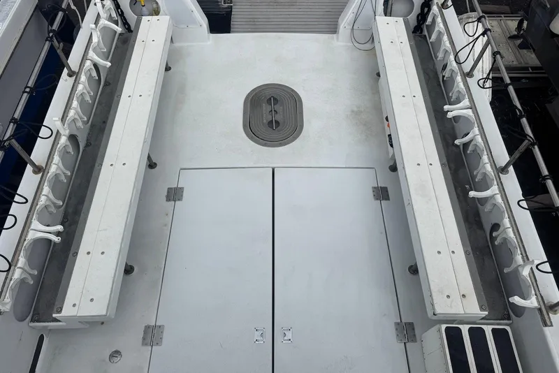 Slide: The Image of 1988 Custom 36 Hawaiian Lightning Radon boat deck with rod holders and storage compartments. - 18