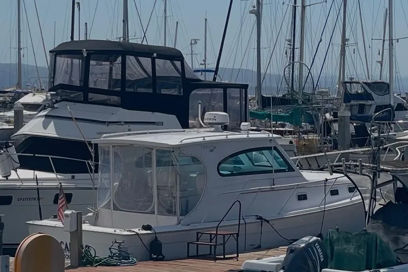 Slide: The Image of 1999 Mainship Pilot 30 docked at marina, labeled "Buccaneer," Half Moon Bay, CA. - 4