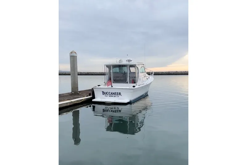 Slide: The Image of 1999 Mainship Pilot 30 docked at a marina with other boats. - 5