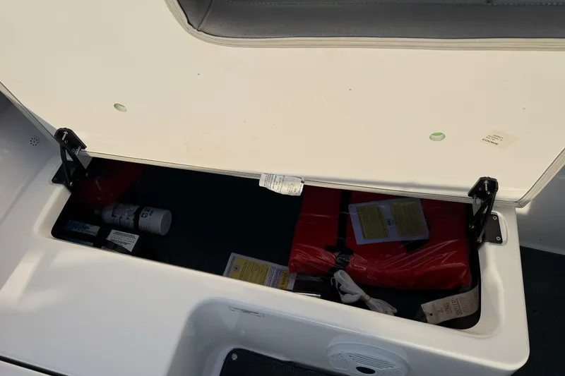 Slide: The Image of 2022 Yamaha Boats SX190 storage compartment with life jackets and safety equipment. - 22