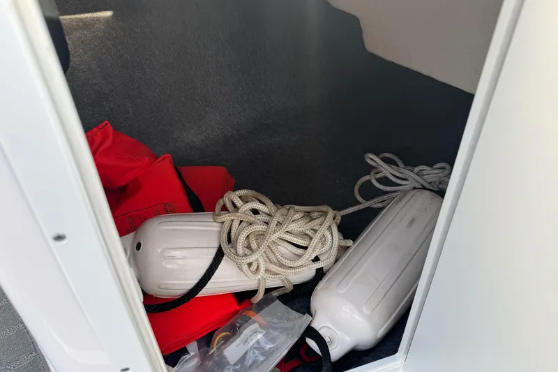 Slide: The Image of 2022 Yamaha SX190 boat storage with life jackets, ropes, and fenders. - 24