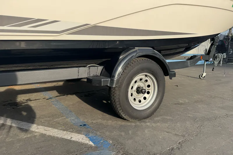 Slide: The Image of 2022 Yamaha Boats SX190 trailer wheel and hull detail in parking lot. - 3