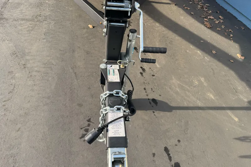 Slide: The Image of Trailer hitch of 2022 Yamaha Boats SX190 with chains and handle on pavement. - 7