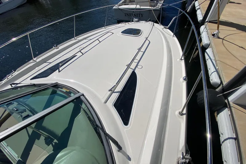 Slide: The Image of 2008 Sea Ray Sundancer 330 yacht docked, showcasing sleek deck design and railing. - 15