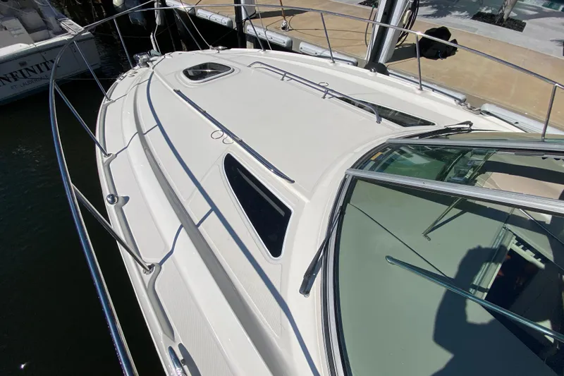 Slide: The Image of 2008 Sea Ray Sundancer 330 yacht docked, showcasing sleek design and spacious deck. - 16