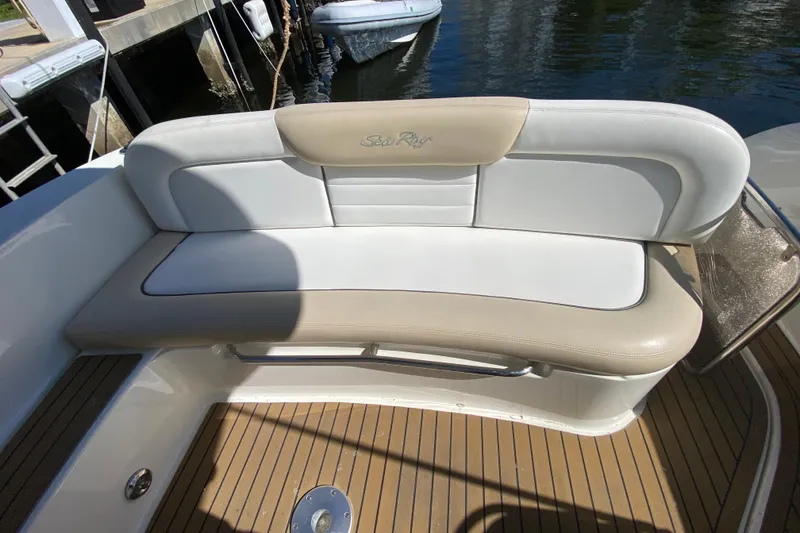 Slide: The Image of 2008 Sea Ray Sundancer 330 boat seating with beige and white upholstery, docked by the water. - 27