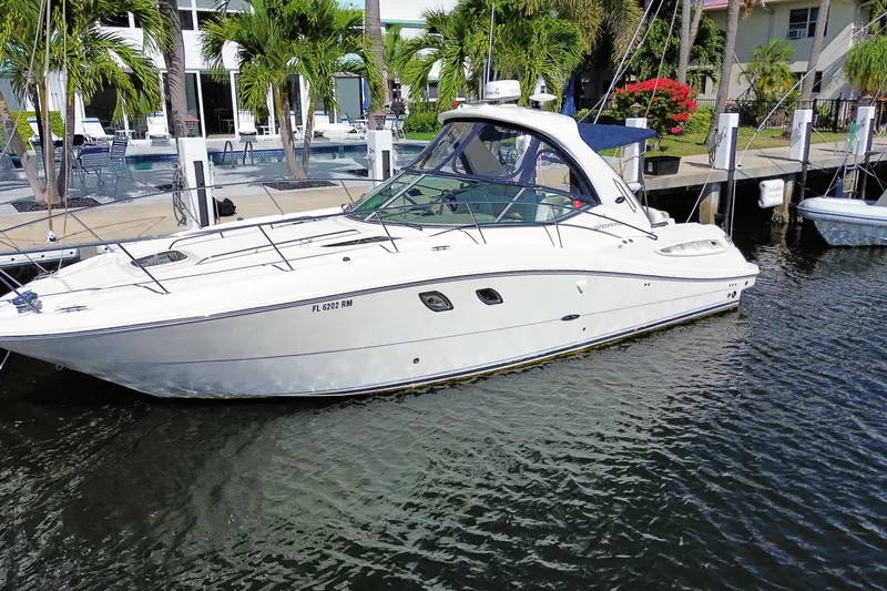 Slide: The Image of 2008 Sea Ray Sundancer 330 yacht docked by palm trees and waterfront homes. - 3