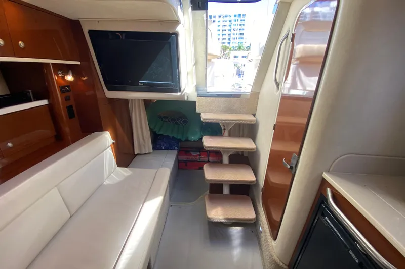 Slide: The Image of 2008 Sea Ray Sundancer 330 interior with sofa, TV, and stairs leading to deck. - 46