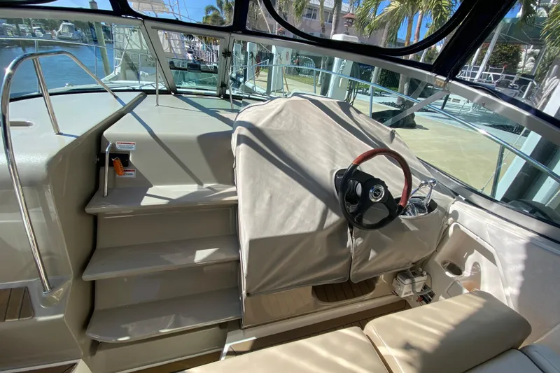 Slide: The Image of 2008 Sea Ray Sundancer 330 helm with covered steering wheel and marina view. - 58