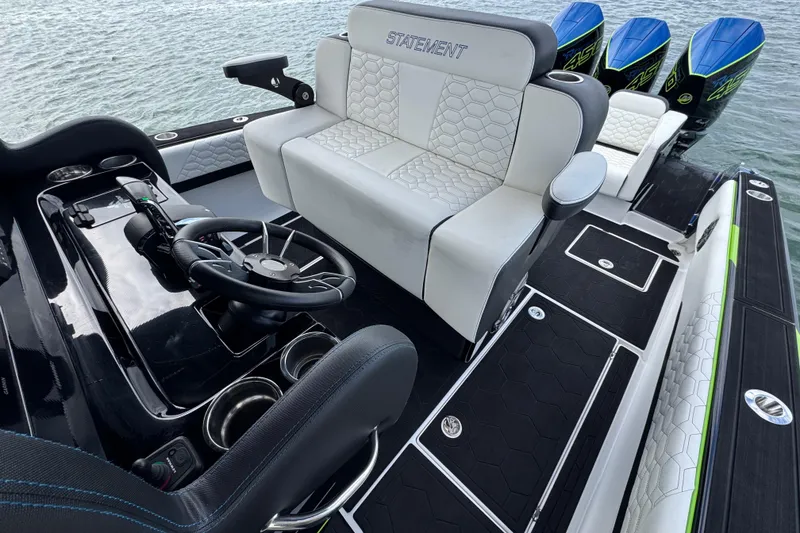 Slide: The Image of 2024 Statement 350 Open boat interior with luxury seating and triple outboard engines. - 14