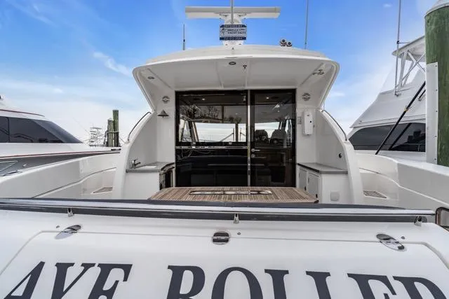 Slide: The Image of 2014 Riviera 4400 Sport Yacht with open deck and sleek design, docked at marina. - 23