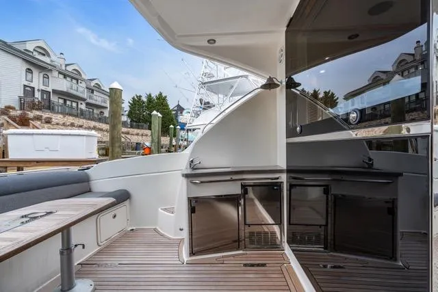 Slide: The Image of 2014 Riviera 4400 Sport Yacht with sleek deck design and modern amenities at a marina. - 27