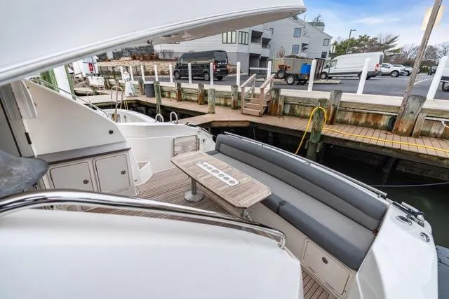 Slide: The Image of 2014 Riviera 4400 Sport Yacht docked, featuring spacious seating and sleek design. - 35