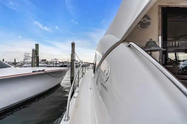 Slide: The Image of 2014 Riviera 4400 Sport Yacht docked at marina under blue sky. - 36