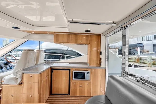 Slide: The Image of Interior of 2014 Riviera 4400 Sport Yacht with modern kitchen and seating area. - 42