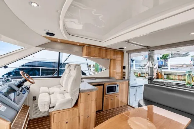 Slide: The Image of Interior of 2014 Riviera 4400 Sport Yacht with modern helm, seating, and kitchenette. - 45