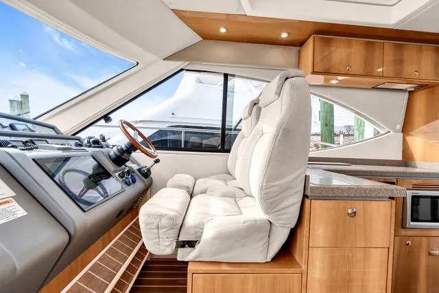 Slide: The Image of 2014 Riviera 4400 Sport Yacht interior with plush seating and modern helm. - 52