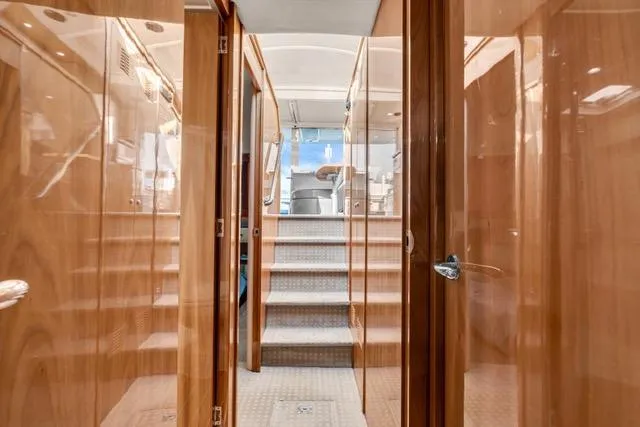 Slide: The Image of Interior view of 2014 Riviera 4400 Sport Yacht with polished wood finish and stairs leading up. - 59