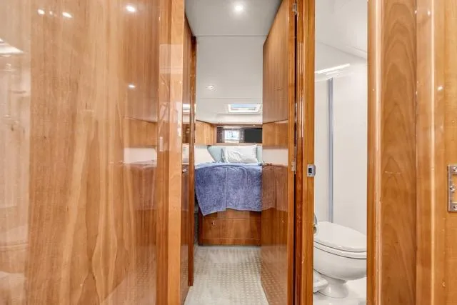 Slide: The Image of Luxurious interior of 2014 Riviera 4400 Sport Yacht with wood paneling and cozy bedroom. - 61