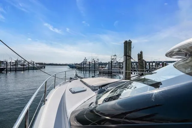 Slide: The Image of 2014 Riviera 4400 Sport Yacht docked at marina under clear blue sky. - 69
