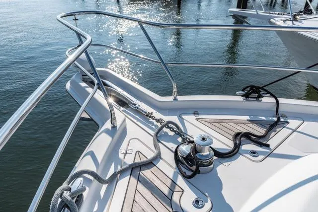 Slide: The Image of 2014 Riviera 4400 Sport Yacht bow with ropes and winch, reflecting sunlight on water. - 70