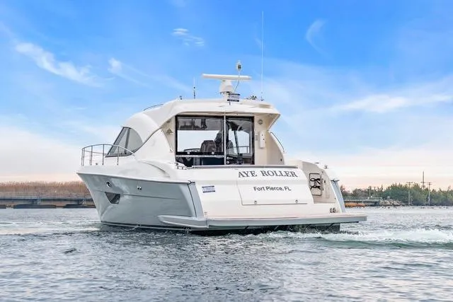 Slide: The Image of 2014 Riviera 4400 Sport Yacht cruising on water under a clear blue sky. - 9