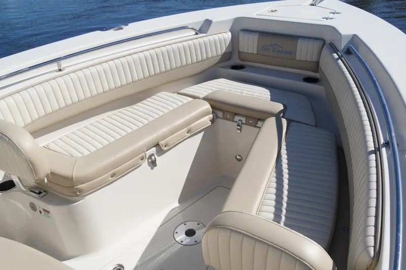 Slide: The Image of 2019 SeaChaser 24 HFC boat interior with beige and white cushioned seating. - 11