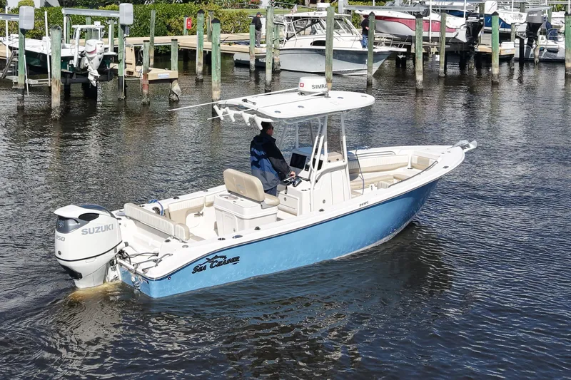 Slide: The Image of 2019 SeaChaser 24 HFC boat with Suzuki engine, docked in a marina. - 2