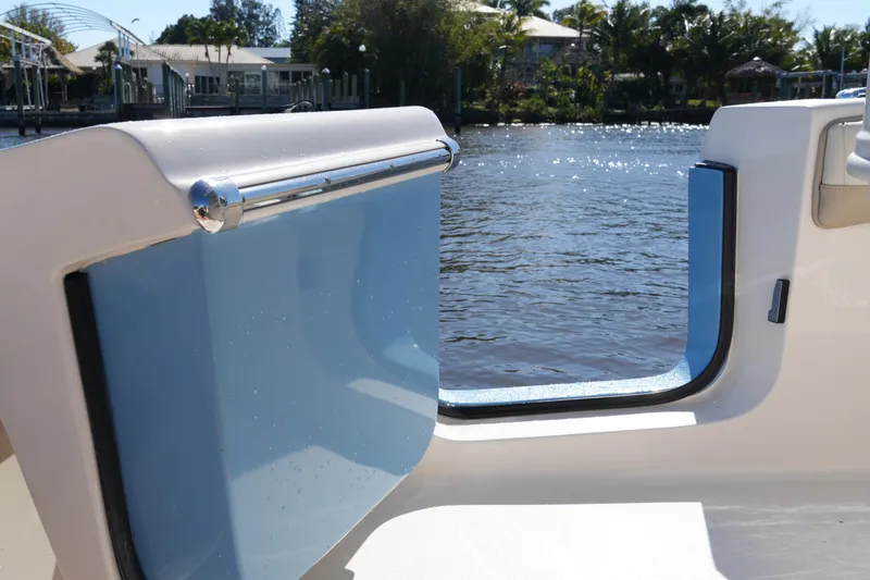 Slide: The Image of 2019 SeaChaser 24 HFC boat with open side door, overlooking serene waterway. - 21