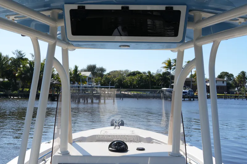 Slide: The Image of 2019 SeaChaser 24 HFC boat on calm water, featuring a sturdy T-top and clear view. - 32