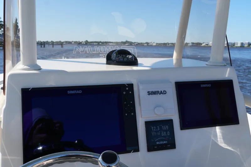Slide: The Image of 2019 SeaChaser 24 HFC boat dashboard with Simrad navigation displays on a sunny day. - 35