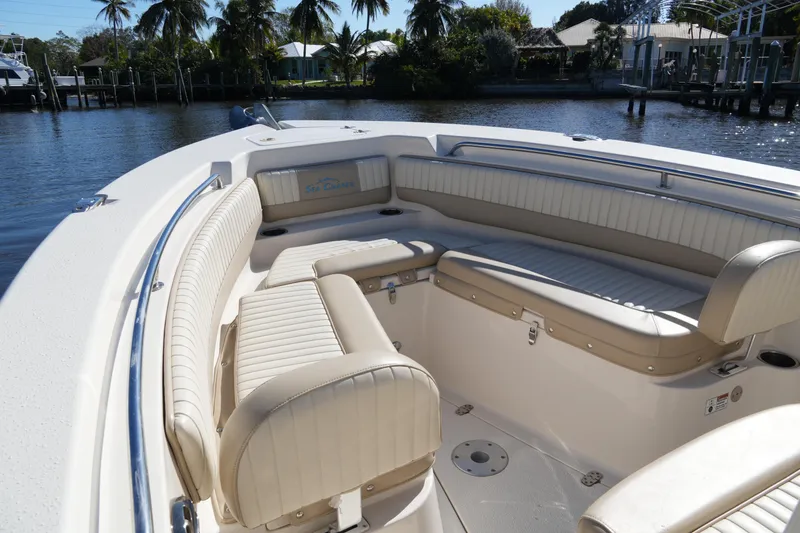 Slide: The Image of 2019 SeaChaser 24 HFC boat interior with cushioned seating and scenic waterfront view. - 10