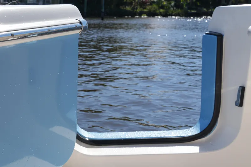 Slide: The Image of 2019 SeaChaser 24 HFC boat with open side door, overlooking calm water. - 22