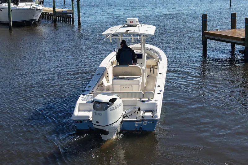 Slide: The Image of 2019 SeaChaser 24 HFC boat with Suzuki engine on calm water near docks. - 3